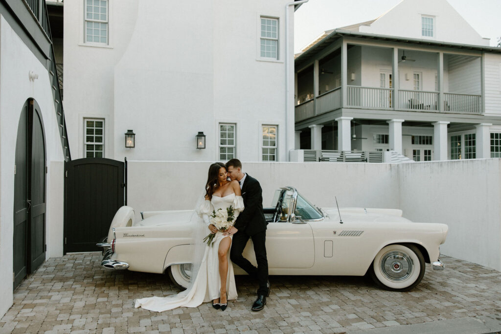 bride and groom leaning against vintage car for elopement in florida