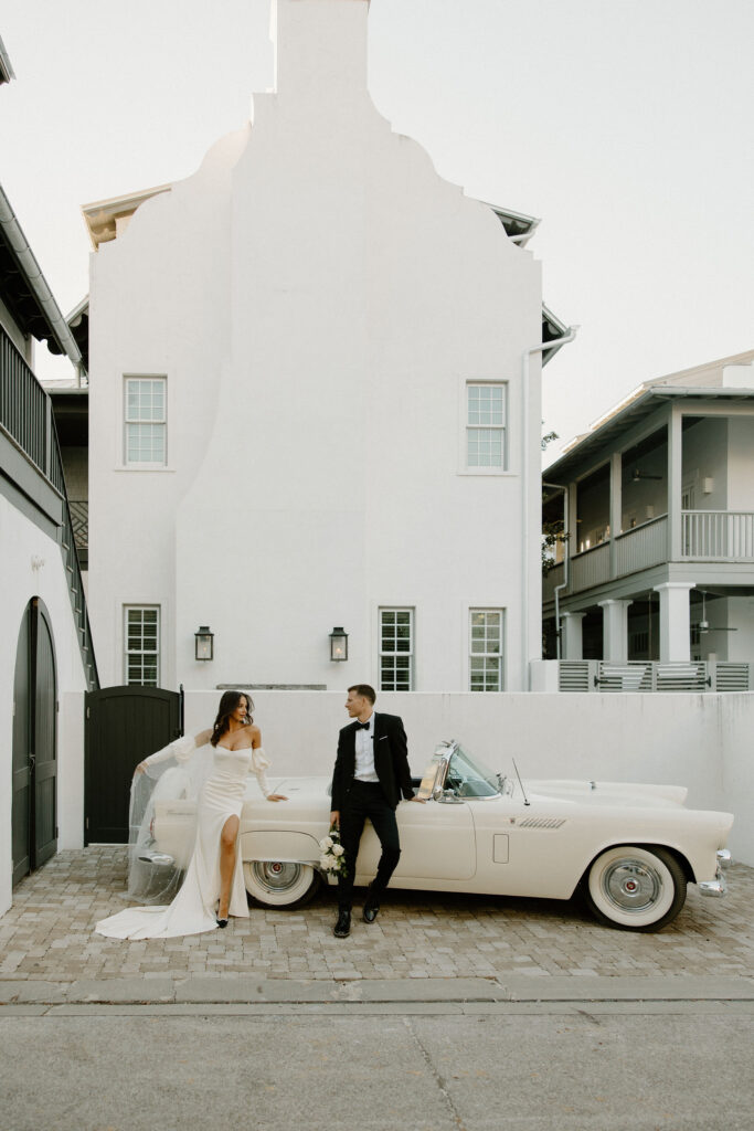 bride and groom posing in front of vintage car