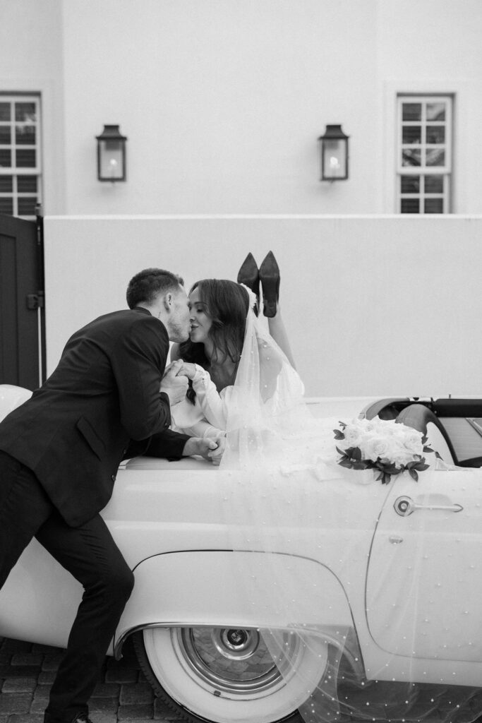 bride and groom kissing on top of vintage car elopement in florida