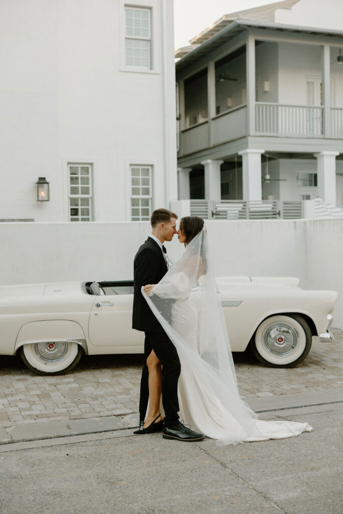 bride and groom posing in front of vintage car in 30A florida for elopement