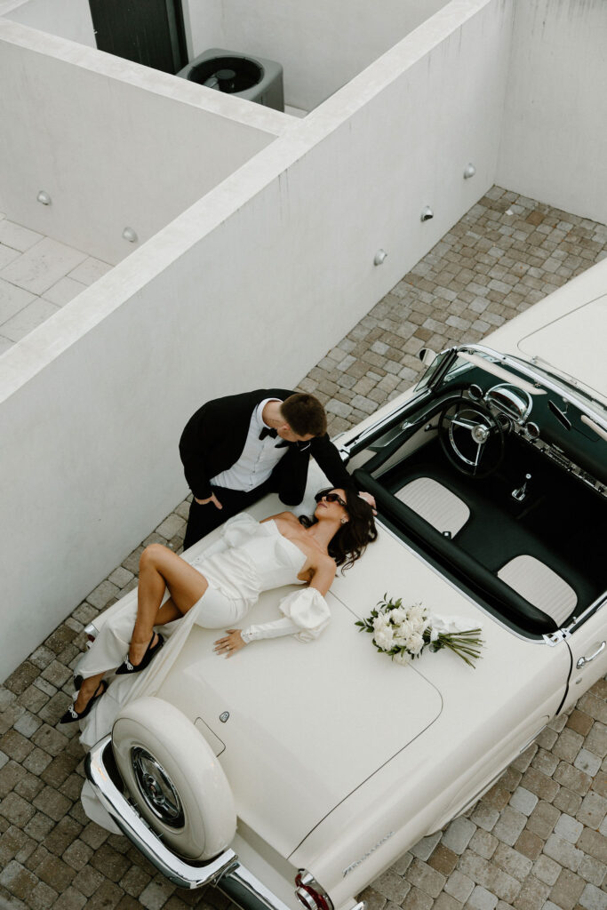 candid and playful elopement photos with vintage car unique bride and groom poses