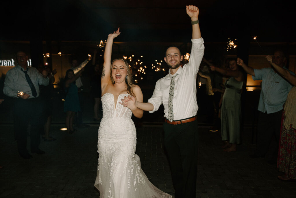 documentary style wedding photos sparkler wedding exit bride and groom smiling