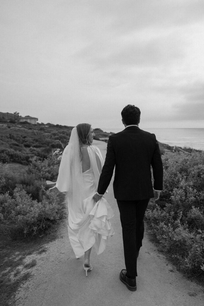 bride and groom walking on san diego beach